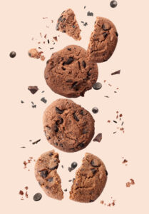 Falling chocolate cookies on light background for social media strategy