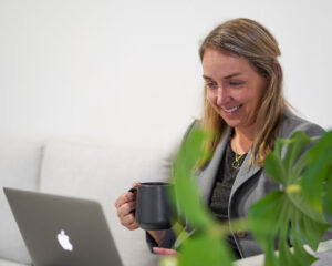 Girl smiling while watching YouTube on her laptop. social media management nz