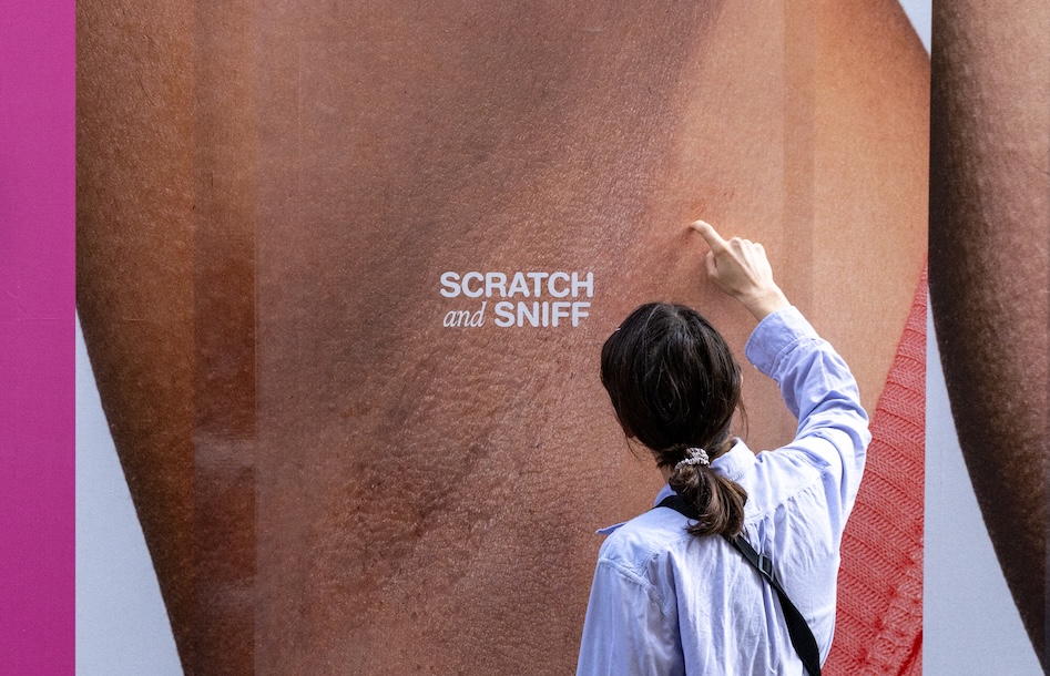 woman scratching and sniffing a billboard